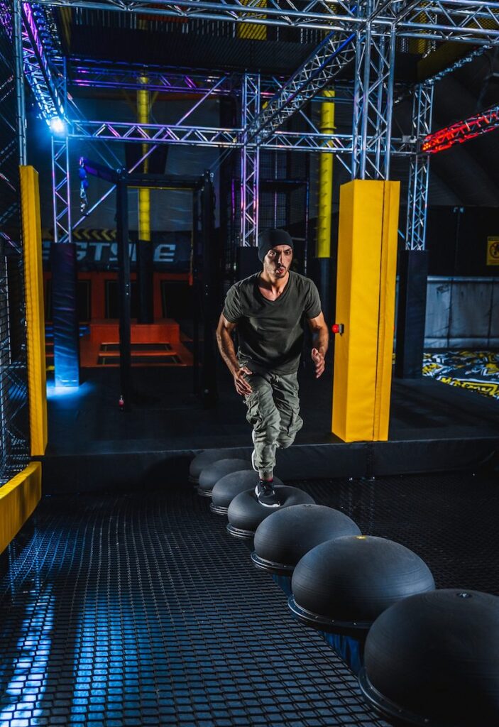 Person auf einem Balance-Element im Ninja Warrior Parcours bei Jumpin Warrior