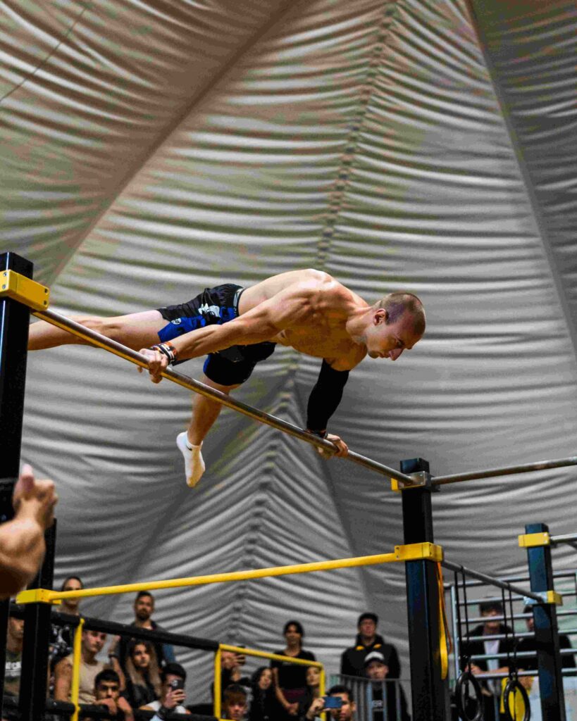 Athlet führt eine Planche auf einer horizontalen Stange während einer Calisthenics-Veranstaltung durch