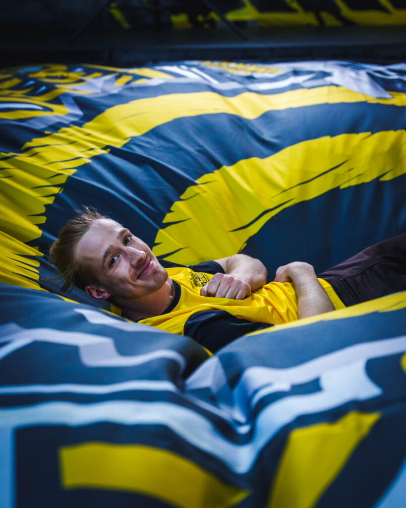 Mann liegt erfreut auf einem großen Air Bags mit Jumpin Warrior Logo