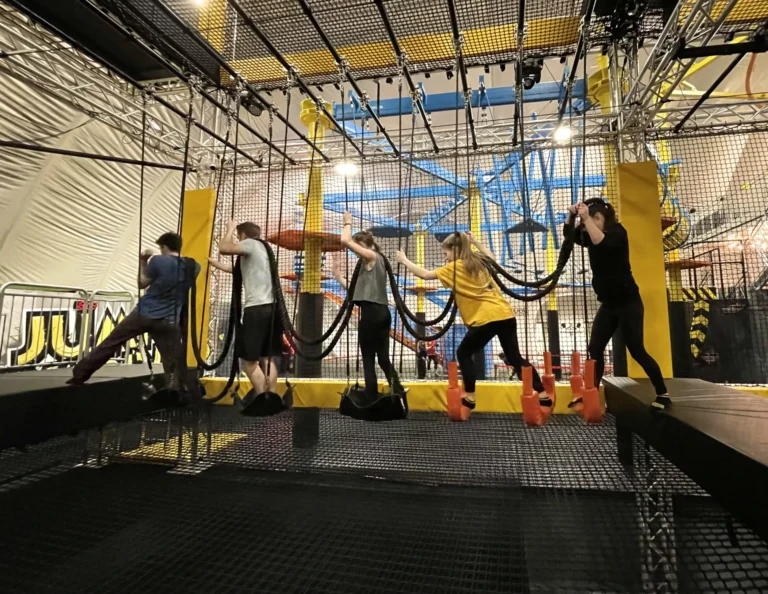 Schulausflug Wien Ideen - Schülergruppe im Trampolinpark Jumpin Warrior in SCS Vösendorf beim Überqueren eines Hindernisses.